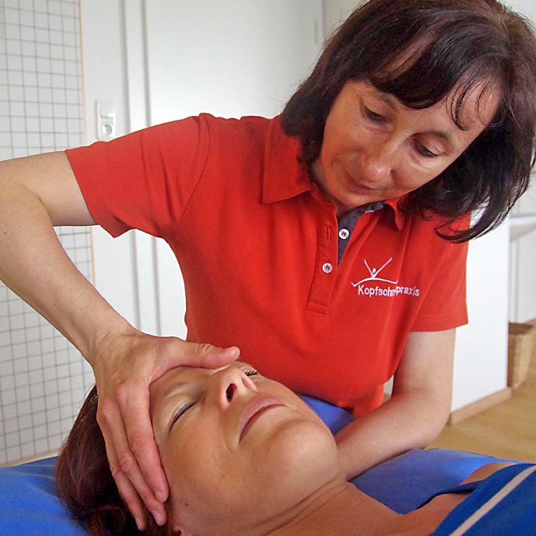 Dipl. Physiotherapeutin Antonia Reschenhofer erklärt Patientin die Fehlstellung anhand eines Wirbelsäulemodells.